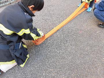 伸ばしたホースを巻きなおす様子